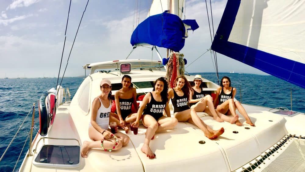 Chicas de despedida de soltera en la proa del catamarán