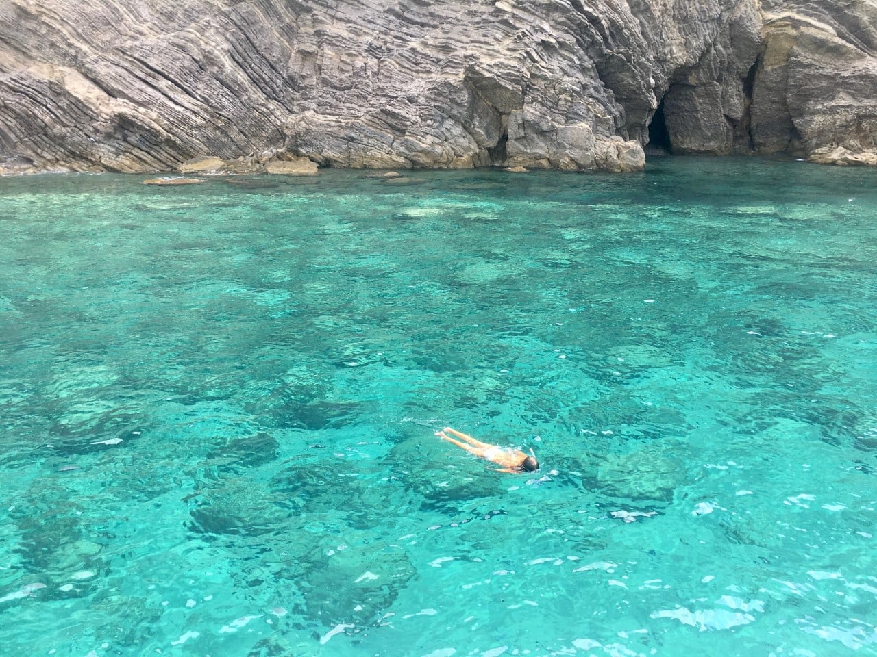 alquiler de catamaran para familia en Ibiza - chico bañándose en aguas cristalinas