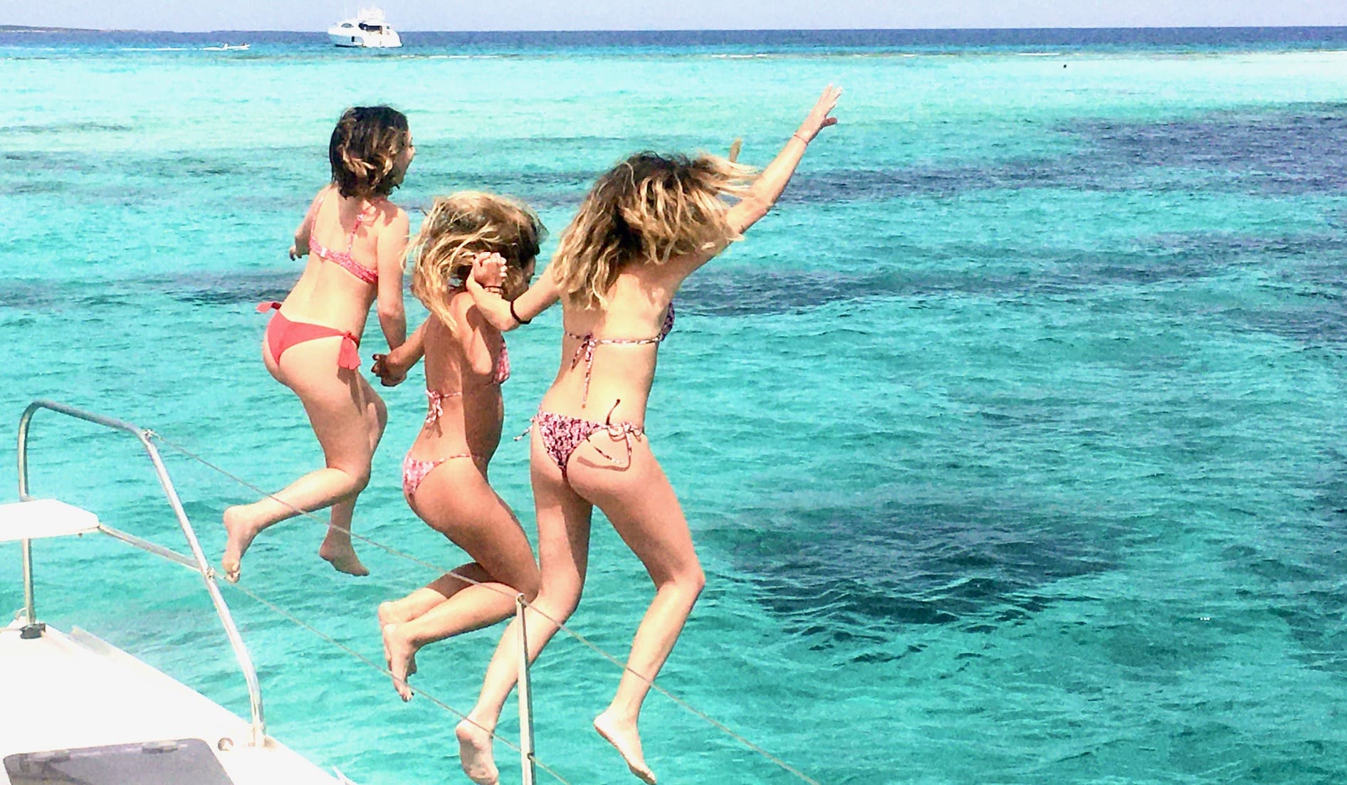 Alquilar catamaran en Ibiza para un día, chicas saltando por la borda