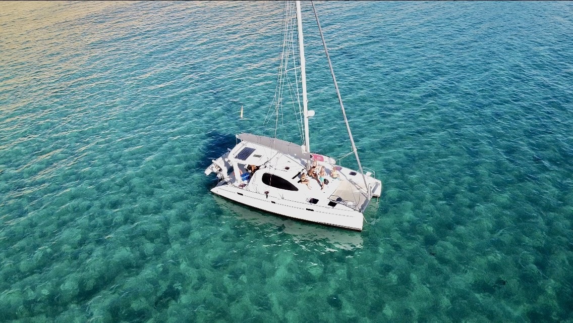 alquilar catamaran Ibiza por un día, geronimo fondeado en aguas turquesas