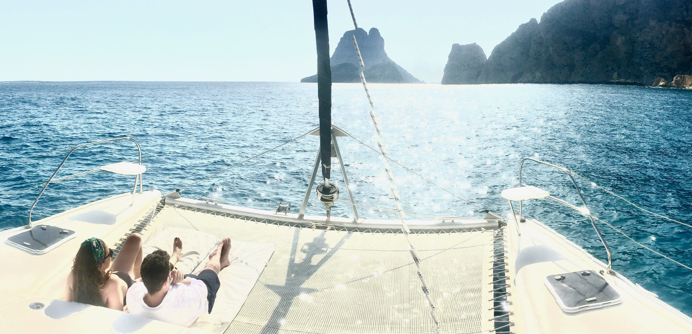 Voyage de noces à Ibiza sur un catamaran, couple profitant de s'allonger sur le filet de notre catmaran 