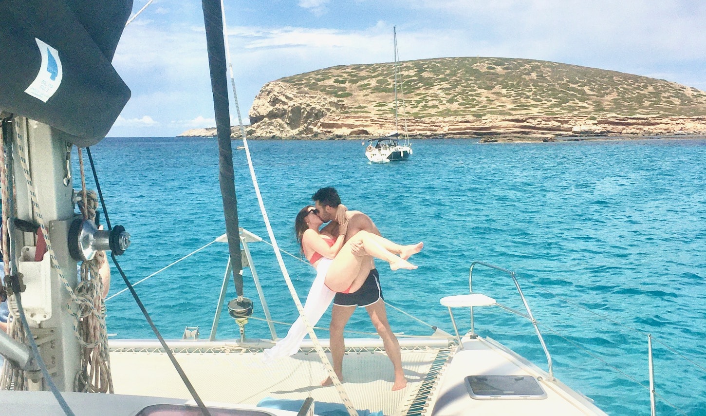 Honeymoon Ibiza catamaran, couple kissing eachother