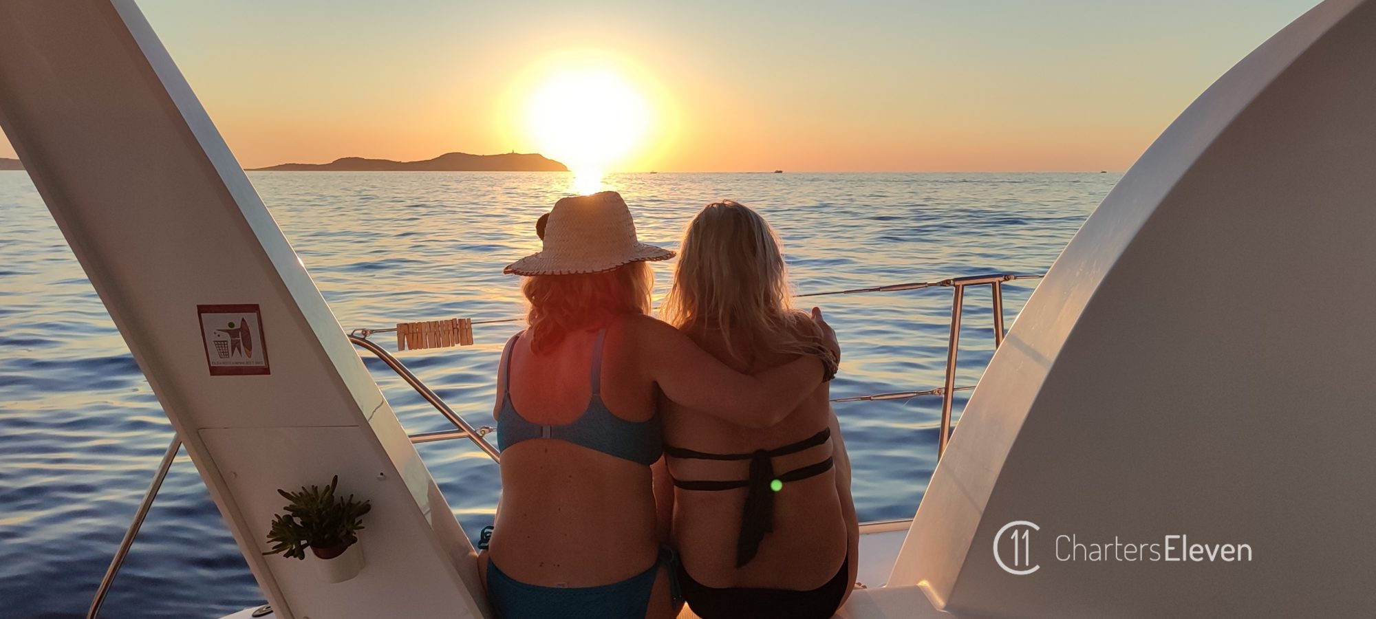 Alquiler de Catamaran en Ibiza. Chicas disfrutando de la puesta de sol.