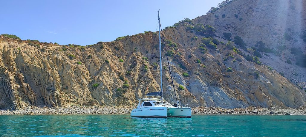 our commitment to the environment - our catamaran at anchor in the beauriful Cala Jondal