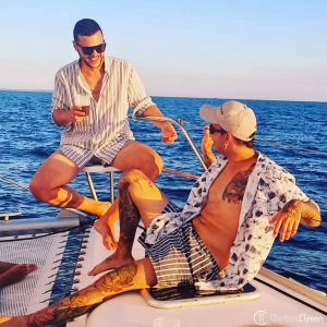 Formentera charter, 2 men at the front of the catamaran while sailing around Formentera